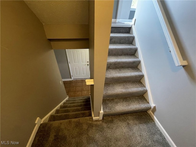stairs featuring baseboards and carpet