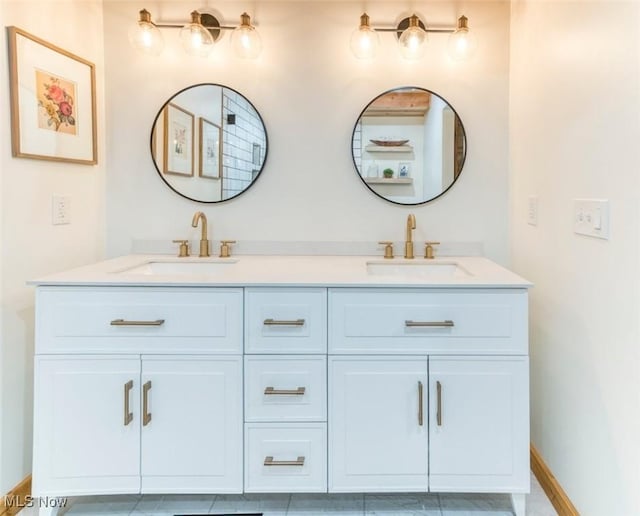 bathroom featuring double vanity, a sink, and baseboards