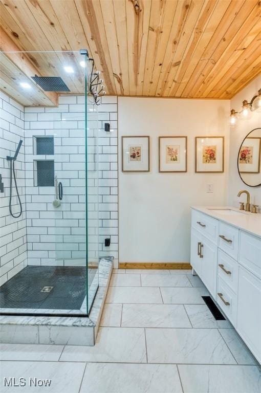 full bathroom featuring vanity, wooden ceiling, baseboards, marble finish floor, and a stall shower