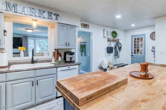 kitchen featuring a sink, light wood finished floors, butcher block countertops, dishwasher, and recessed lighting