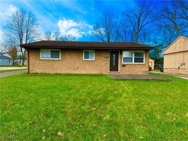 ranch-style home featuring brick siding and a front lawn