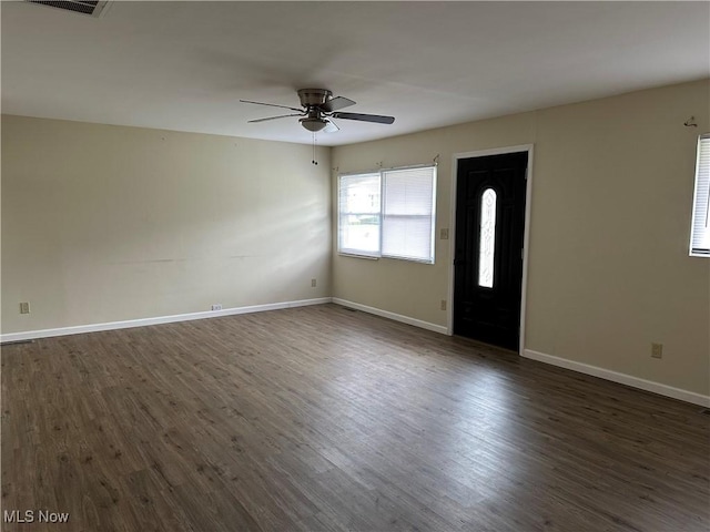 interior space with baseboards, dark wood-style flooring, and a ceiling fan