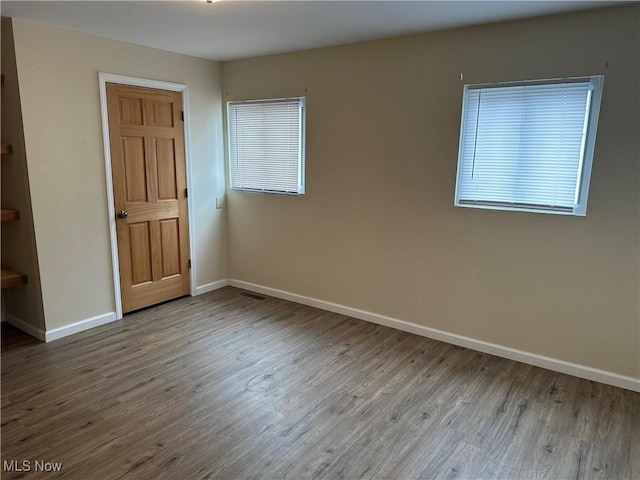 unfurnished room featuring baseboards and wood finished floors