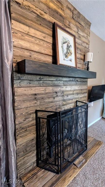 interior details featuring baseboards, a fireplace, carpet flooring, and a textured ceiling