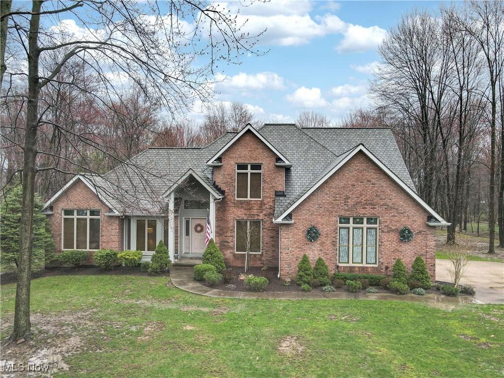 traditional-style home with a front lawn and brick siding
