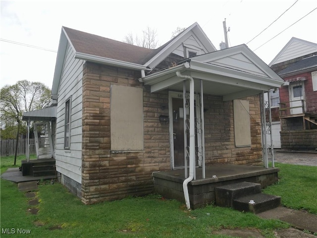 view of front facade featuring stone siding and a front yard
