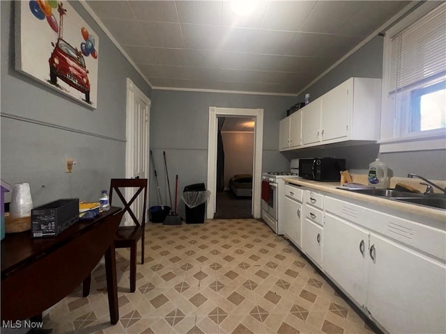 kitchen featuring white gas stove, black microwave, white cabinets, and ornamental molding