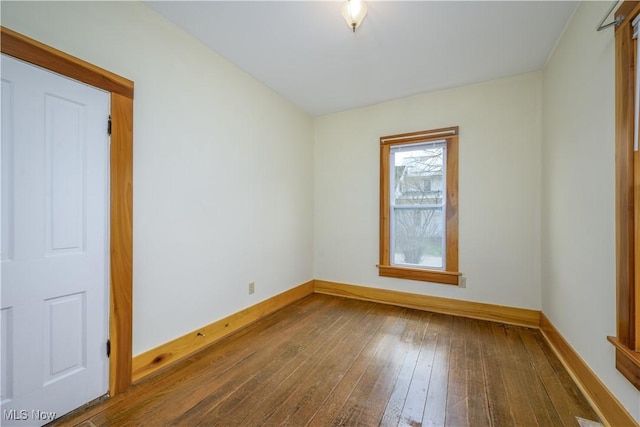 unfurnished room featuring hardwood / wood-style flooring and baseboards