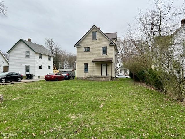 119 Erie St, Elyria, OH 44035 - rear view of house with a yard