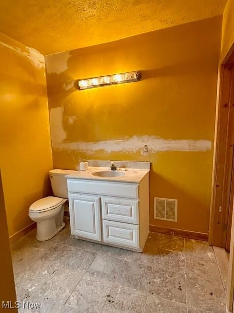 119 Erie St, Elyria, OH 44035 - half bathroom featuring toilet, vanity, a textured ceiling, baseboards, and visible vents