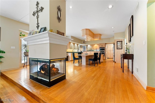 174 N Broad St, Canfield, OH 44406 - living area with recessed lighting, light wood-type flooring, visible vents, and a multi sided fireplace