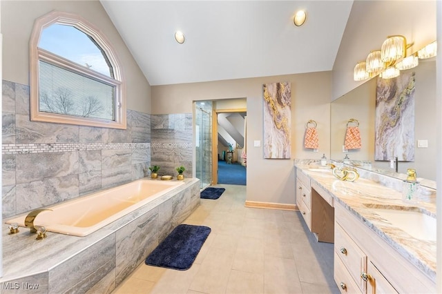 174 N Broad St, Canfield, OH 44406 - full bathroom with a sink, a bath, double vanity, baseboards, and lofted ceiling