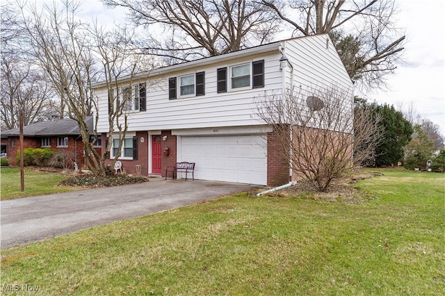 colonial home with brick siding, a garage, a front lawn, and driveway