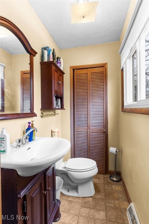 bathroom with toilet, a textured ceiling, visible vents, and vanity