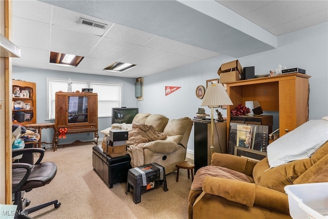 carpeted living area featuring visible vents and a paneled ceiling