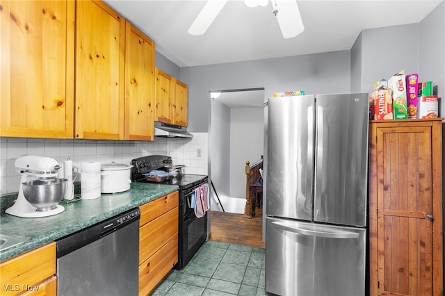 kitchen featuring decorative backsplash, dark countertops, under cabinet range hood, a ceiling fan, and appliances with stainless steel finishes