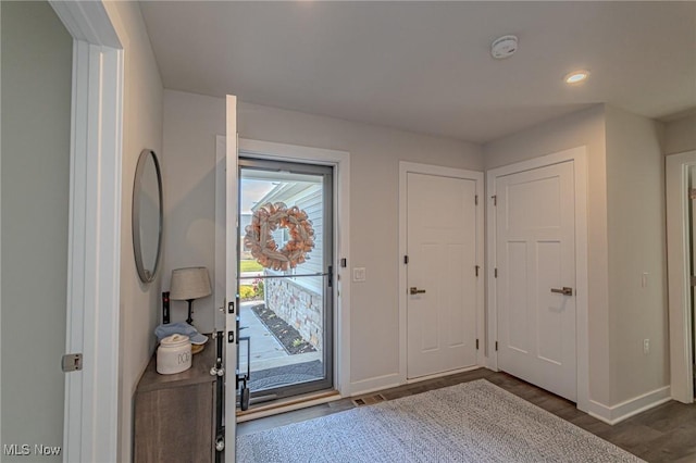 entryway with wood finished floors, baseboards, and recessed lighting
