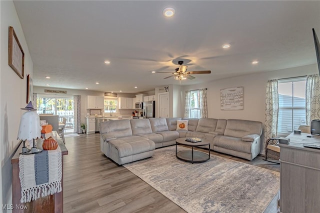 living room with recessed lighting, light wood-type flooring, and a ceiling fan