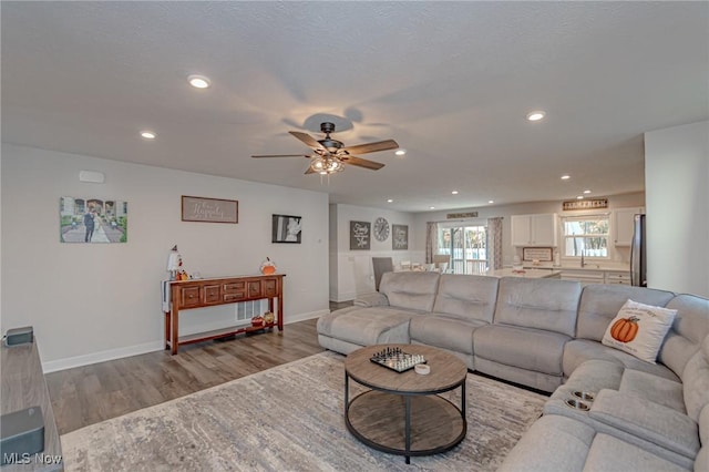 living room with recessed lighting, baseboards, a ceiling fan, and wood finished floors