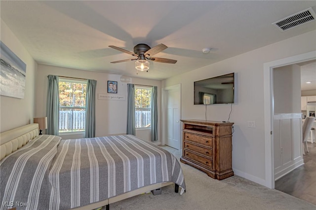 carpeted bedroom with baseboards, a ceiling fan, and visible vents