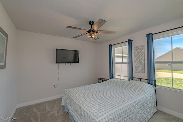 bedroom featuring light colored carpet, baseboards, and ceiling fan