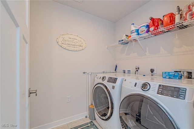 washroom with laundry area, washing machine and clothes dryer, baseboards, and light tile patterned floors
