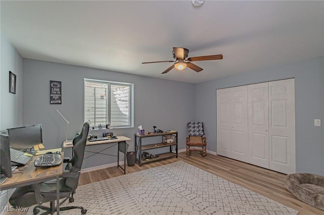 office area with ceiling fan, light wood-type flooring, and baseboards