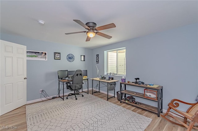 home office featuring baseboards, light wood-type flooring, and a ceiling fan