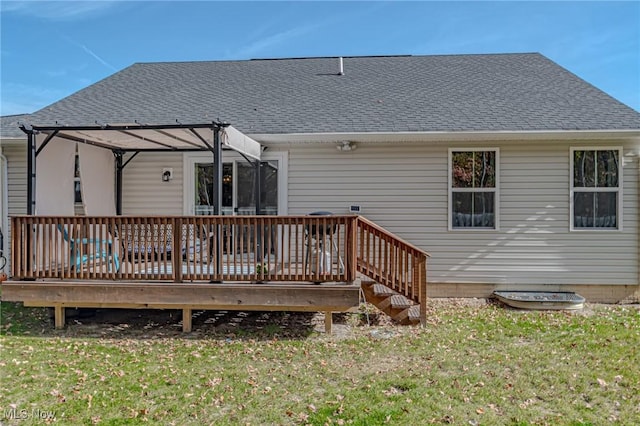 exterior space with a shingled roof, a wooden deck, and a lawn