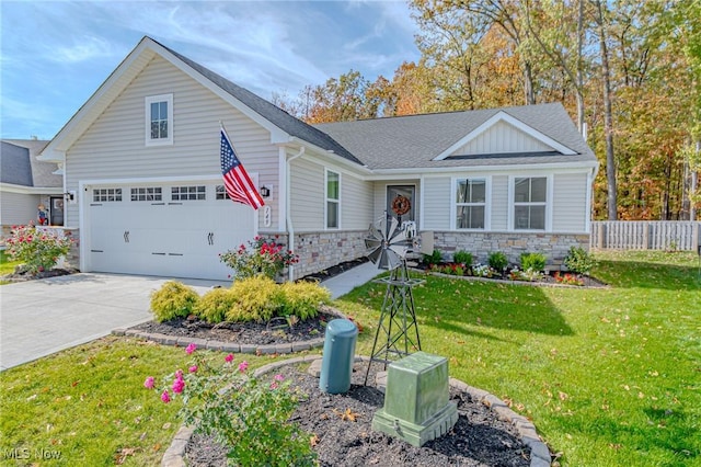 view of front of home featuring a front yard, fence, stone siding, a shingled roof, and driveway