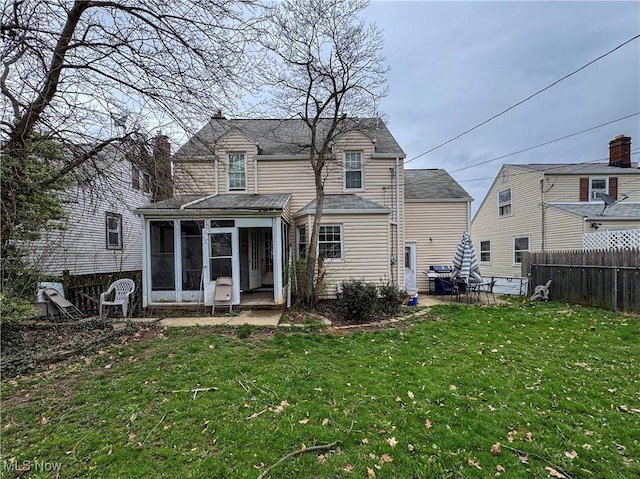 back of house featuring a yard, fence, a patio, and a sunroom
