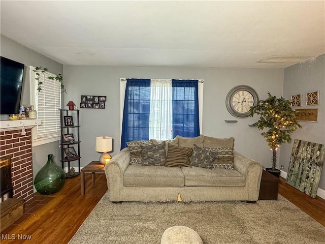 living room with a fireplace and wood finished floors