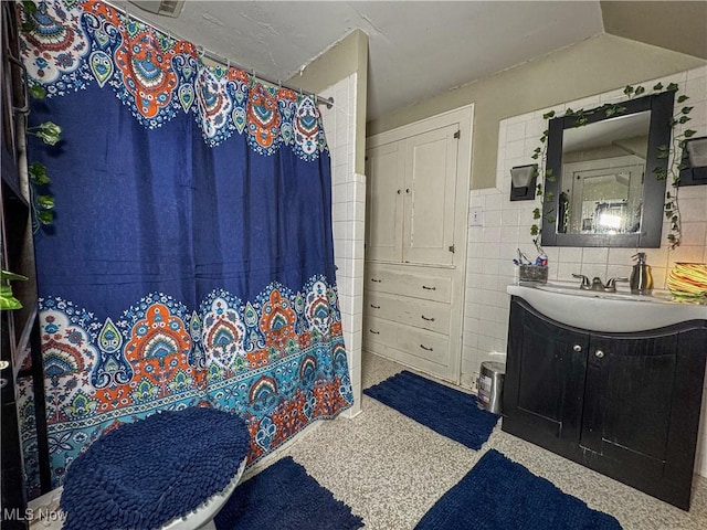 bathroom with vanity, a shower with shower curtain, and tile walls