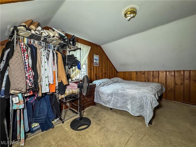 bedroom featuring carpet flooring, wooden walls, and lofted ceiling