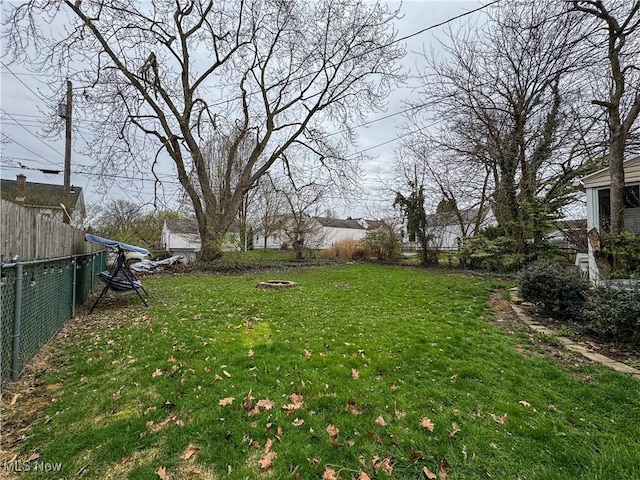 view of yard with a fenced backyard and a fire pit