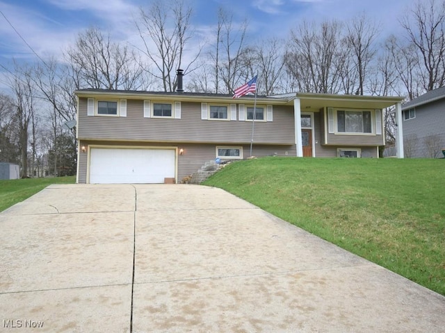 bi-level home featuring a garage, driveway, a chimney, and a front lawn