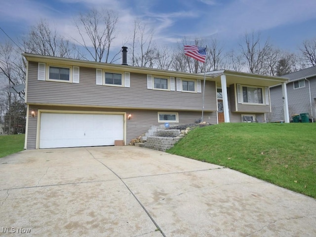 raised ranch with driveway, a front lawn, and a garage