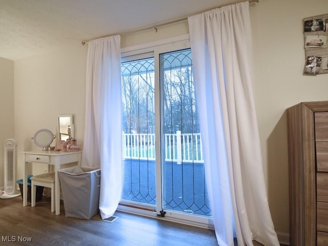 bedroom featuring access to outside, visible vents, and wood finished floors