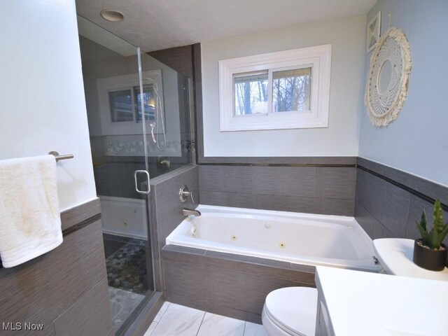 bathroom with toilet, a stall shower, vanity, and a tub with jets