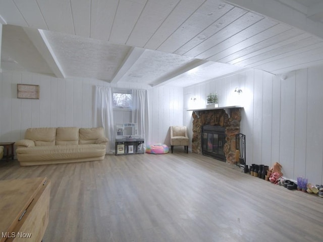 unfurnished living room featuring wood finished floors, beamed ceiling, a fireplace, and wooden ceiling