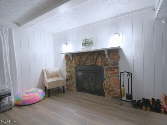 interior space with a fireplace, wood finished floors, and a textured ceiling
