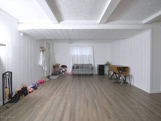 game room featuring a textured ceiling, wood finished floors, and beam ceiling