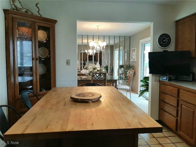 dining area featuring light tile patterned flooring and a notable chandelier