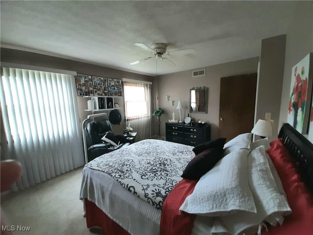 carpeted bedroom featuring visible vents and a ceiling fan