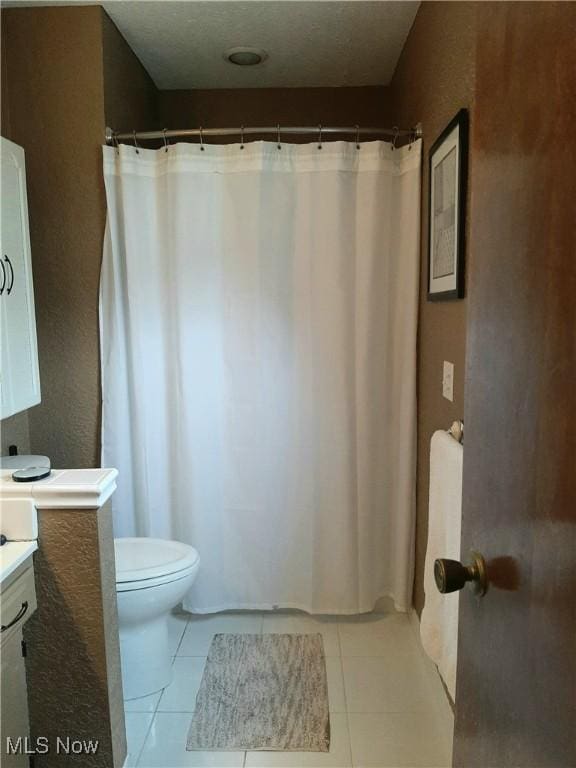 full bathroom with toilet, curtained shower, vanity, and tile patterned flooring