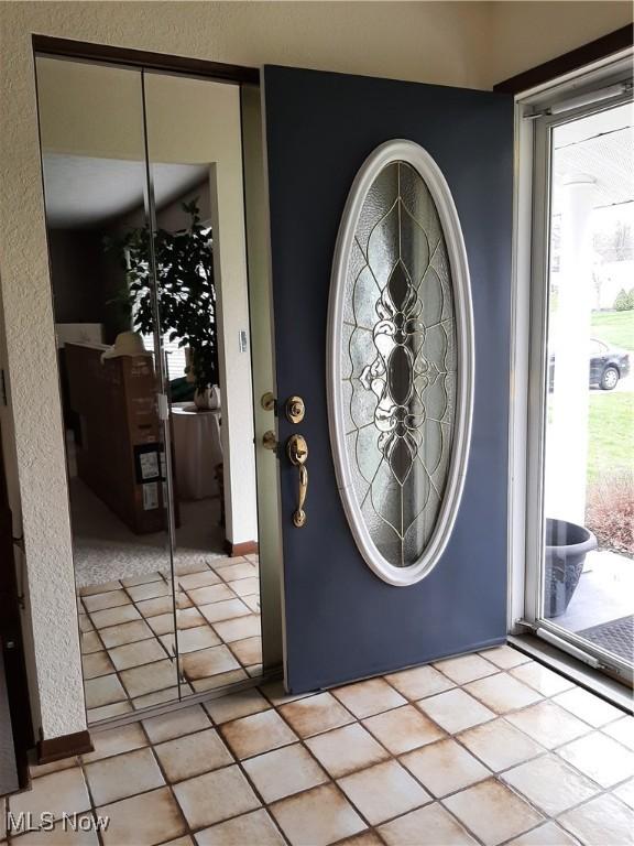 entryway with light tile patterned flooring