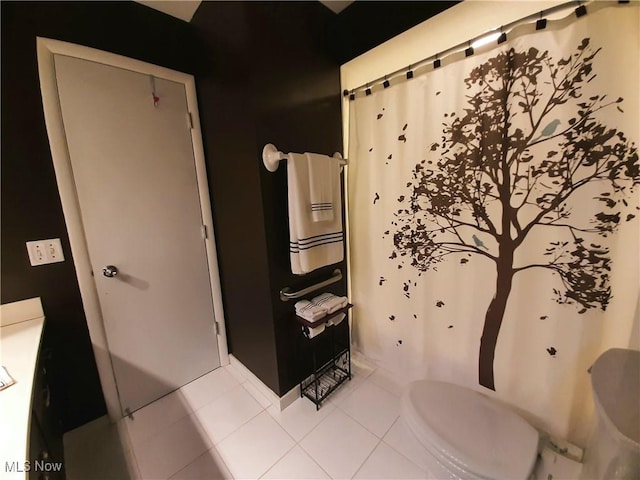 full bath featuring toilet, tile patterned floors, and a shower with curtain