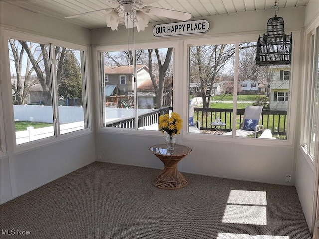 unfurnished sunroom featuring carpet floors and a healthy amount of sunlight