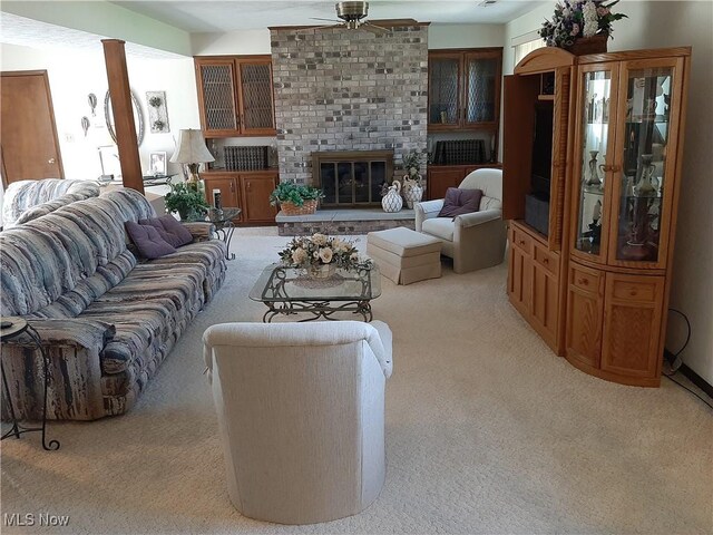 living room with light carpet, a fireplace, and a ceiling fan
