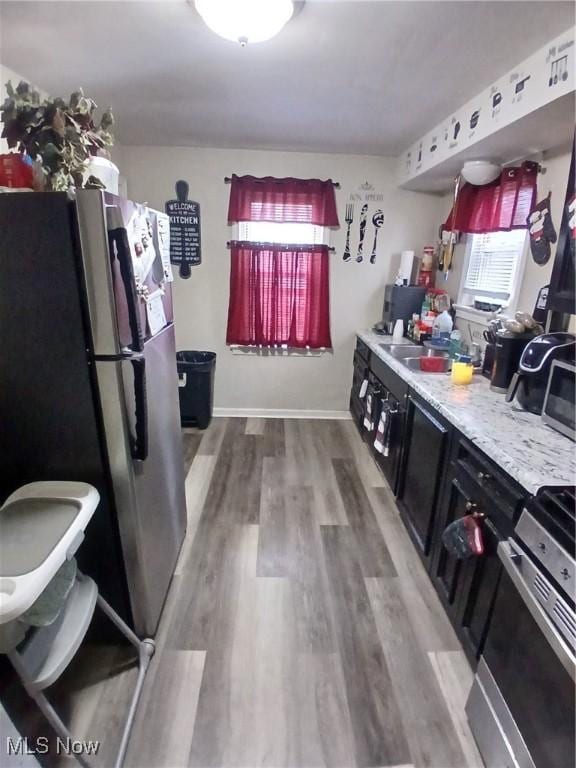 181 E Judson Ave, Youngstown, OH 44507 - kitchen featuring appliances with stainless steel finishes, light wood-style floors, light countertops, a sink, and dark cabinets